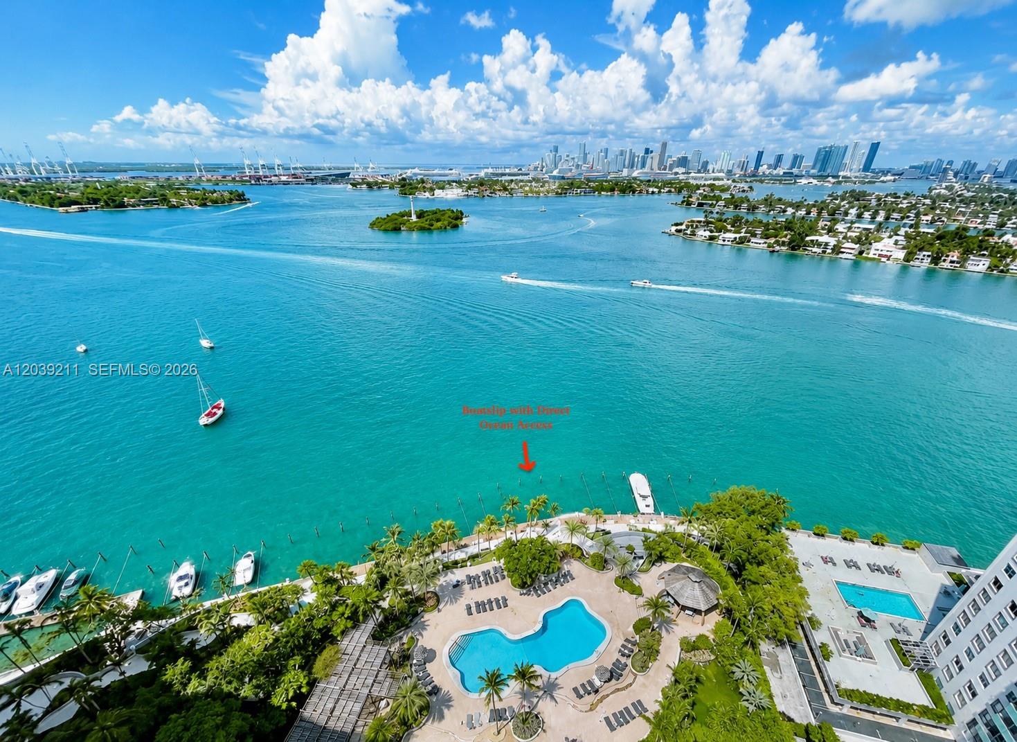 An aerial view shows a swimming pool, palm trees, and a boat dock on the water — 9 Island Ave # 1114, Miami Beach FL 33139, MIAMI BEACH, FL
