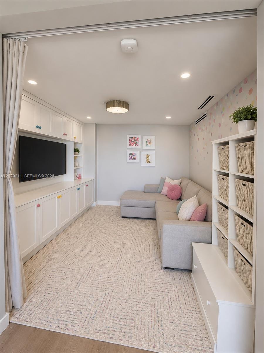 A media room features a sectional sofa, built-in cabinetry, and a patterned area rug — 9 Island Ave # 1114, Miami Beach FL 33139, MIAMI BEACH, FL