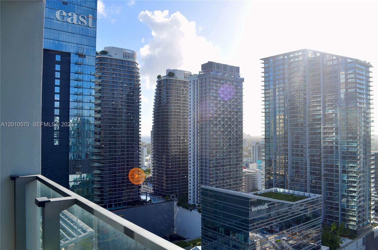 A view from a balcony overlooking several modern glass skyscrapers in a city — 68 SE 6th St # 2708, Miami FL 33131, MIAMI, FL