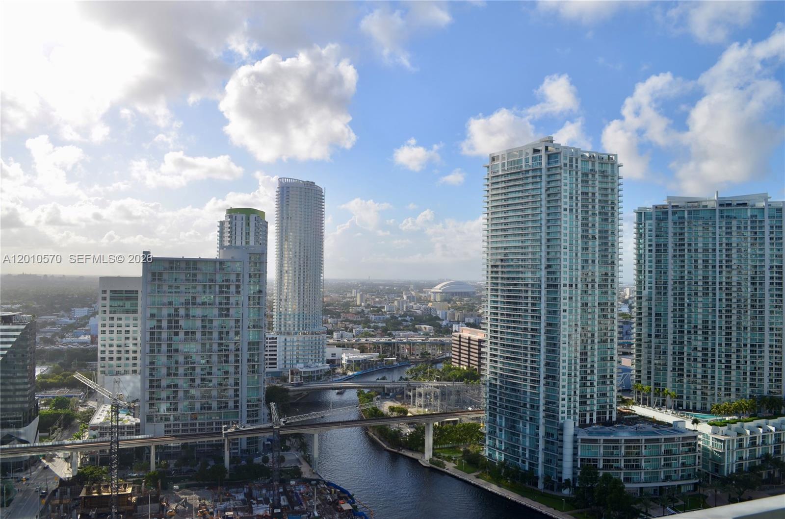 An elevated view of high-rise apartment buildings overlooking a river and city skyline — 68 SE 6th St # 2708, Miami FL 33131, MIAMI, FL