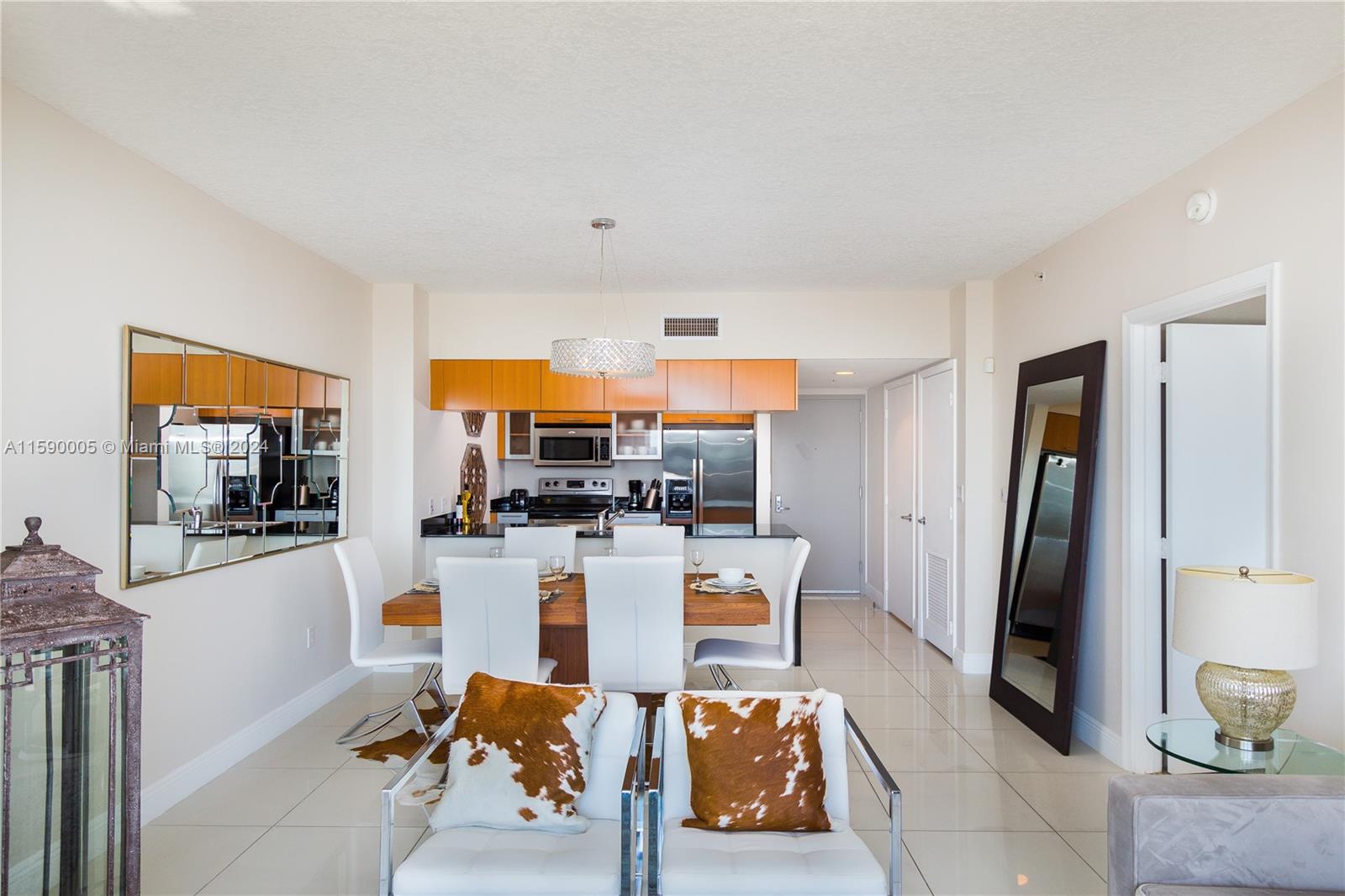 A dining area with a wooden table, white chairs, and an adjacent open kitchen — 1750 N Bayshore Dr # 3512, Miami FL 33132, MIAMI, FL