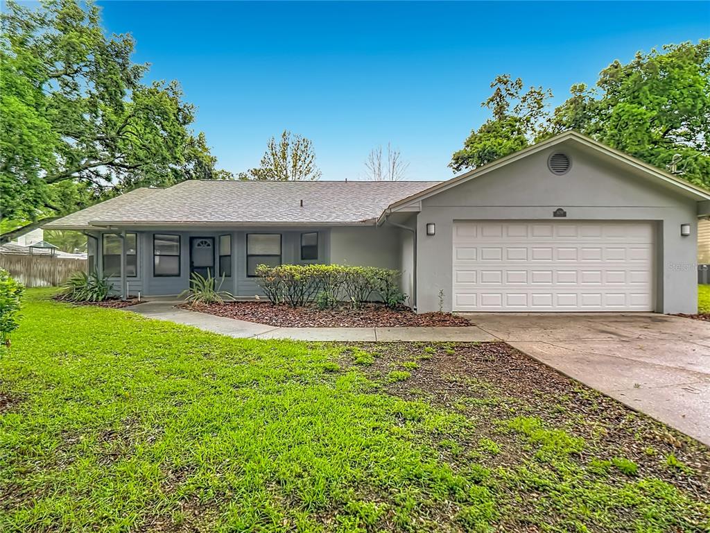 A single-story house with a gray exterior, a two-car garage, and a front lawn — 109 SOUTH COURT, AUBURNDALE, FL