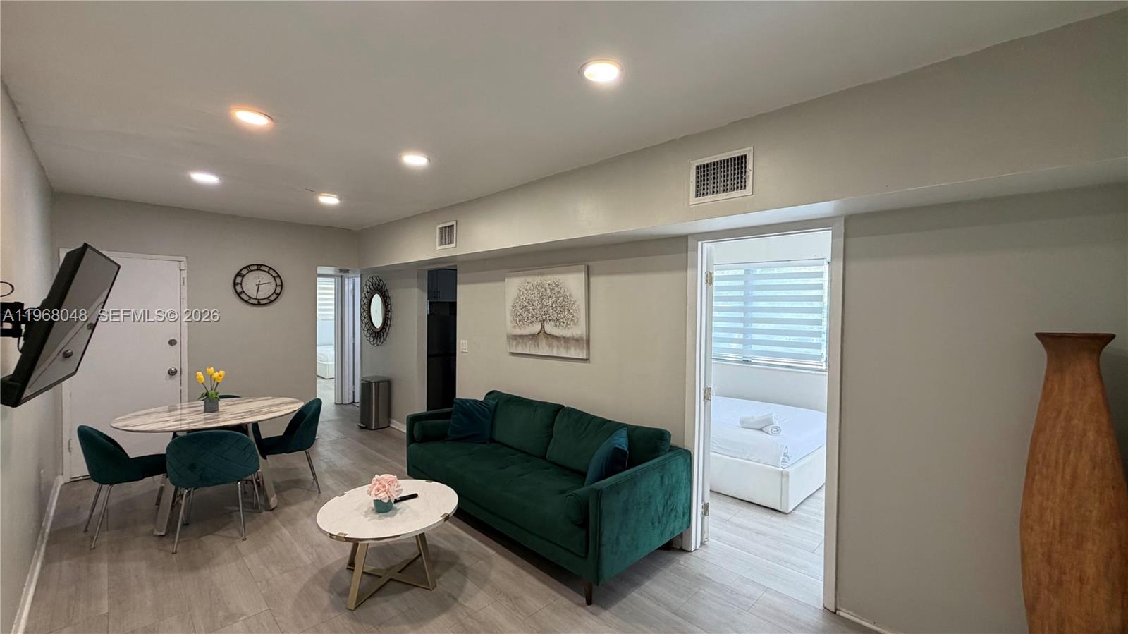 This living room features a green sofa, a dining table, and an adjacent bedroom — 10004 E Bay Harbor Dr # 10, Bay Harbor Islands FL 33154, BAY HARBOR ISLANDS, FL