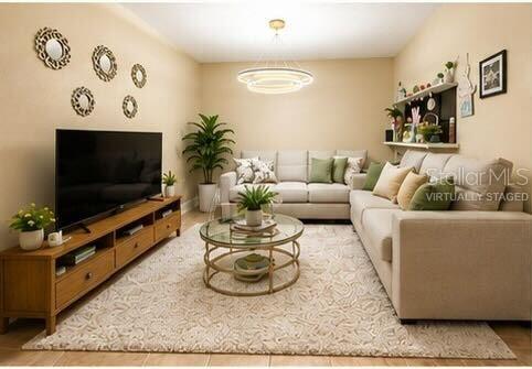 A living room features a beige sofa, a wooden media console, and a circular coffee table — 4704 JASMINE CREEK LANE UNIT 1508A, ORLANDO, FL