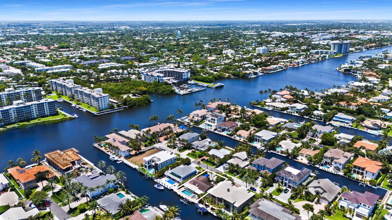 An aerial view shows a residential neighborhood with houses and apartment buildings along a canal — 1018 Brooks Lane, Delray Beach FL 33483, DELRAY BEACH, FL