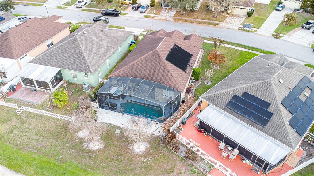 An aerial view shows three suburban houses with screened-in pools and solar panels on roofs — 10196 ANDOVER POINT CIRCLE, ORLANDO, FL