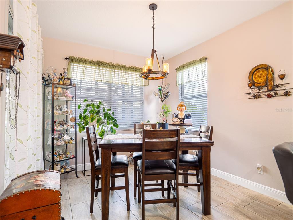 A dining room features a wooden table, chairs, a glass display cabinet, and a chandelier — 10196 ANDOVER POINT CIRCLE, ORLANDO, FL