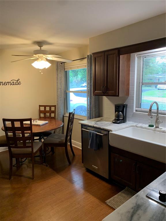 A kitchen with dark wood cabinets, a farmhouse sink, and an adjacent dining area — 1501 INDIANA AVENUE, PALM HARBOR, FL