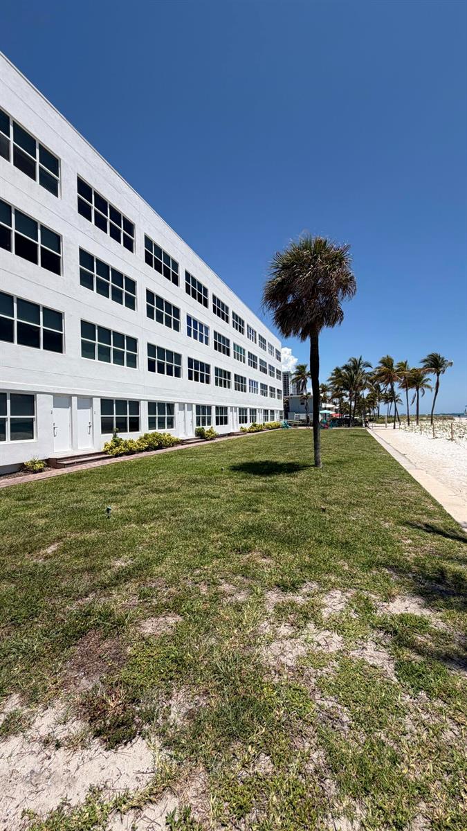 A multi-story white building sits beside a grassy lawn and a sandy beach — 1801 S Surf Road # 2a, Hollywood FL 33019, HOLLYWOOD, FL
