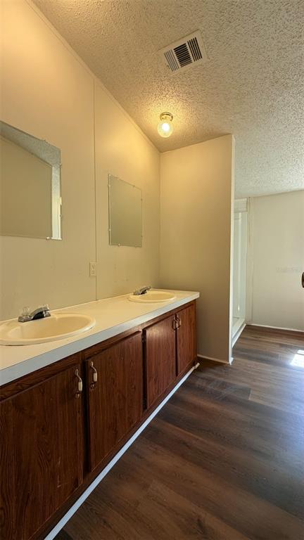 A bathroom features a double vanity with wood cabinets, white countertops, and two wall mirrors — 1910 40TH STREET NW, WINTER HAVEN, FL