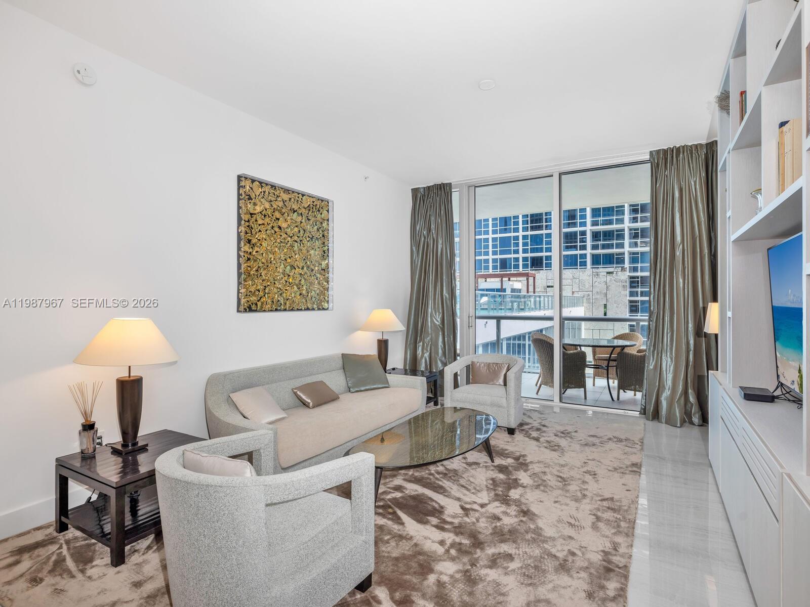 A living room features a sofa, two armchairs, a coffee table, and a balcony view — 6799 Collins Ave # 501, Miami Beach FL 33141, MIAMI BEACH, FL