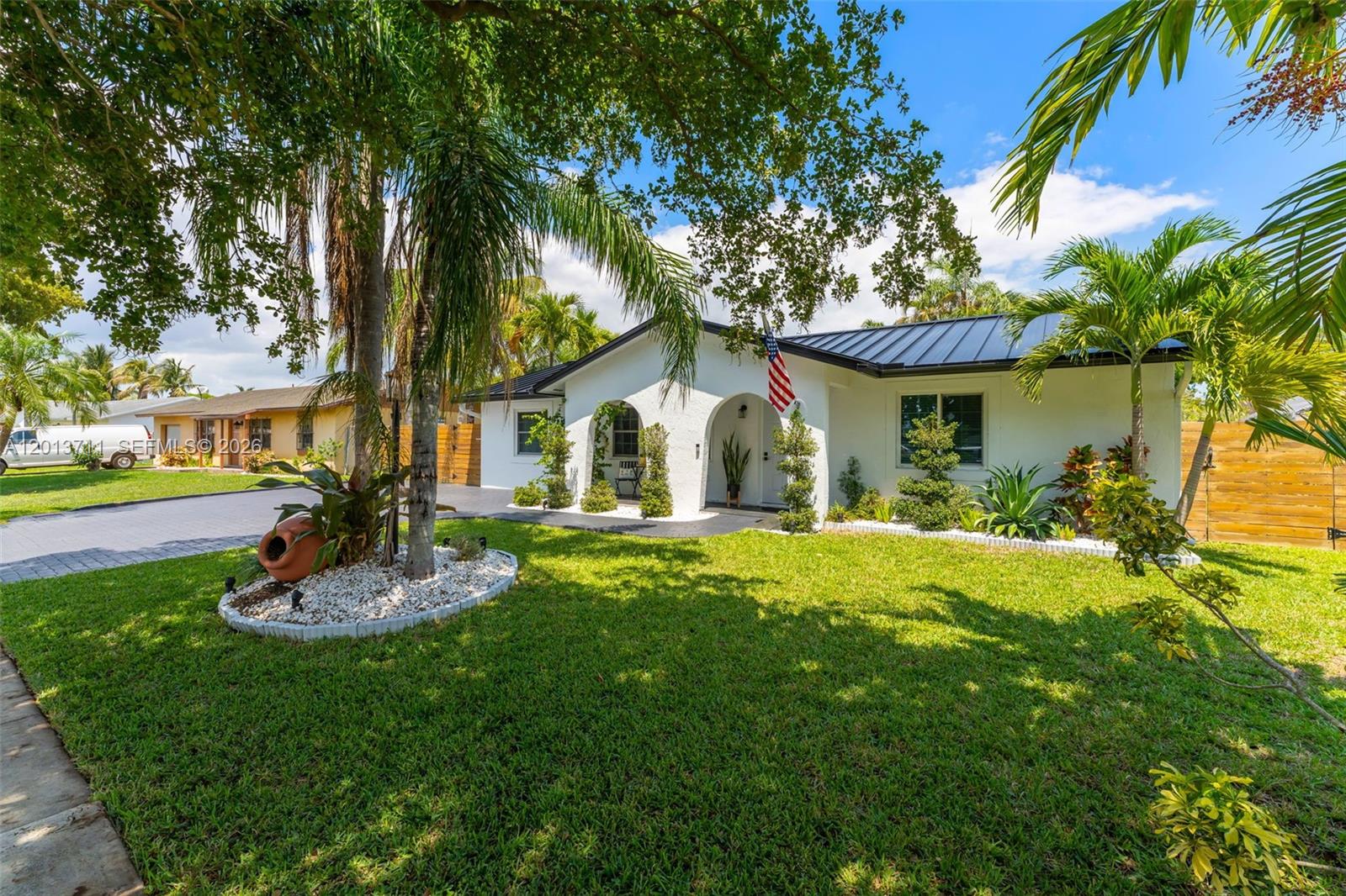 A single-story white house with a dark metal roof and an arched entryway — 6651 SW 148th Court, Miami FL 33193, MIAMI, FL
