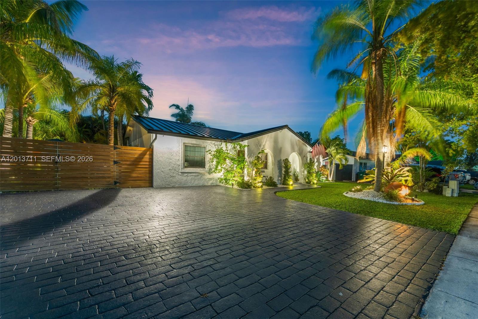 A single-story house with a dark brick driveway, palm trees, and a wooden fence — 6651 SW 148th Court, Miami FL 33193, MIAMI, FL
