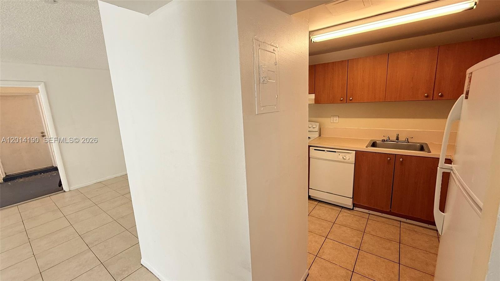 A kitchen with wood cabinets, a white dishwasher, and a white refrigerator — 415 Executive Center Dr # 203, West Palm Beach FL 33401, WEST PALM BEACH, FL