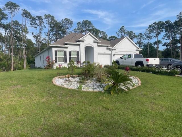 A single-story house with a white exterior, a front garden bed, and a parked truck — 6476 DUNBARTON STREET, NORTH PORT, FL