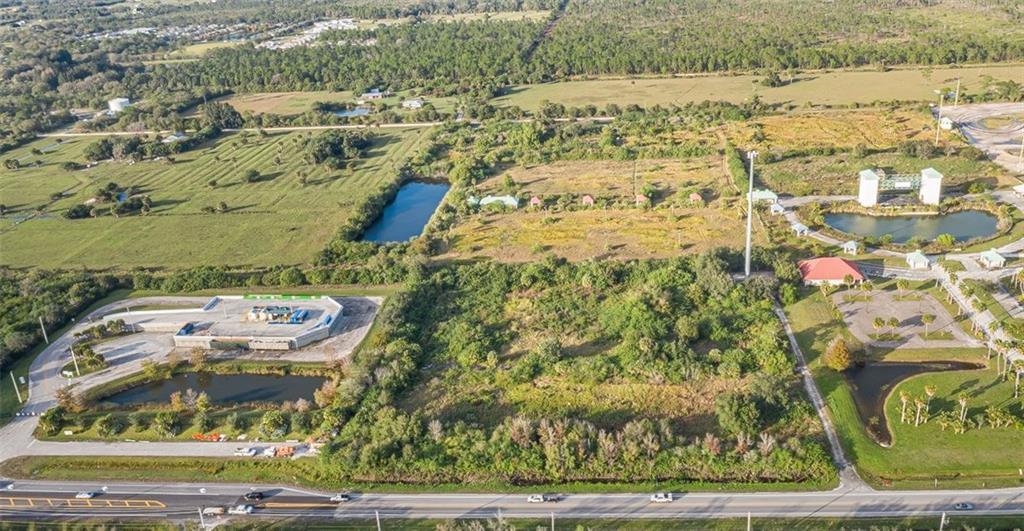 An aerial view shows a large, undeveloped plot of land with ponds and nearby buildings — 9555 Mesa Park Boulevard, Fellsmere FL 32948, FELLSMERE, FL