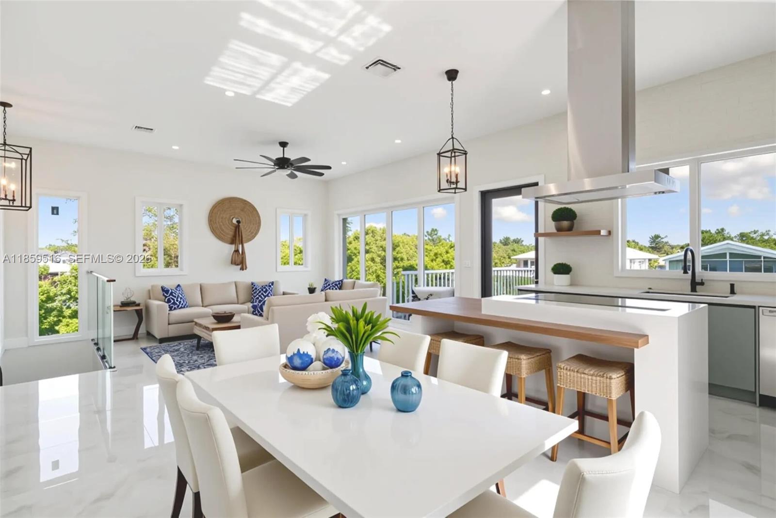 A bright open-concept living and dining area features white tile floors, modern furniture, and cabinetry — 862 Cardinal Ln, Key Largo FL 33037, KEY LARGO, FL