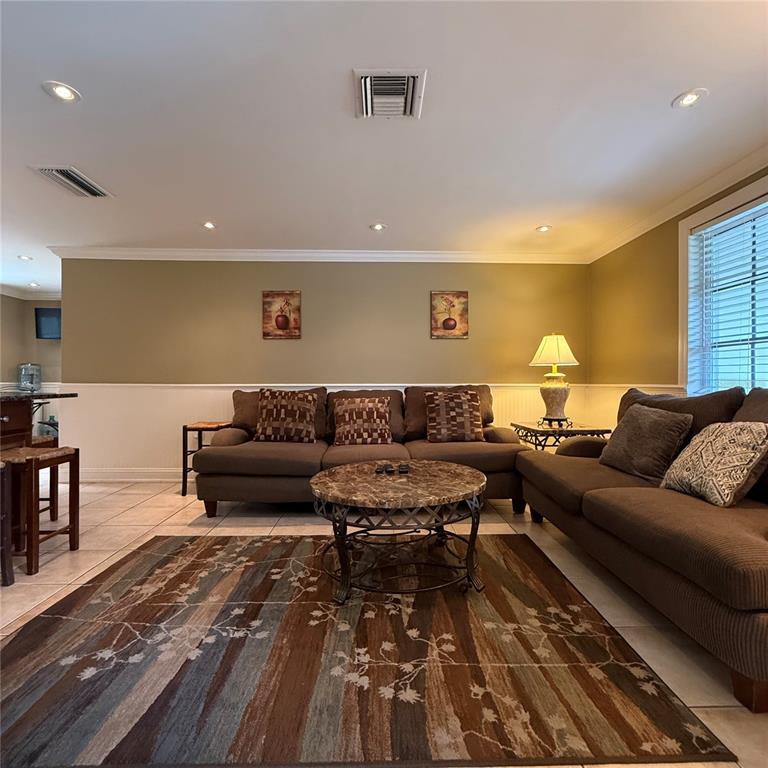 A living room features brown sofas, a patterned area rug, and a marble coffee table — 695 ALLIGATOR DRIVE, VENICE, FL