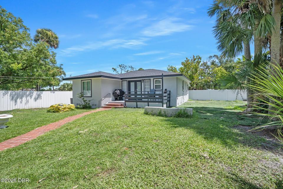 The exterior of a single-story house features a brick walkway, a deck, and a fenced yard — 419 BURLEIGH AVENUE, HOLLY HILL, FL