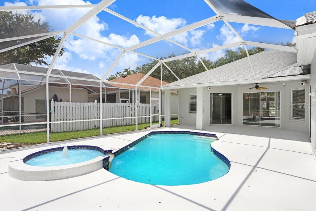A screened-in patio features a swimming pool with an attached spa and a fountain — 10227 QUAILS LANDING AVENUE, TAMPA, FL