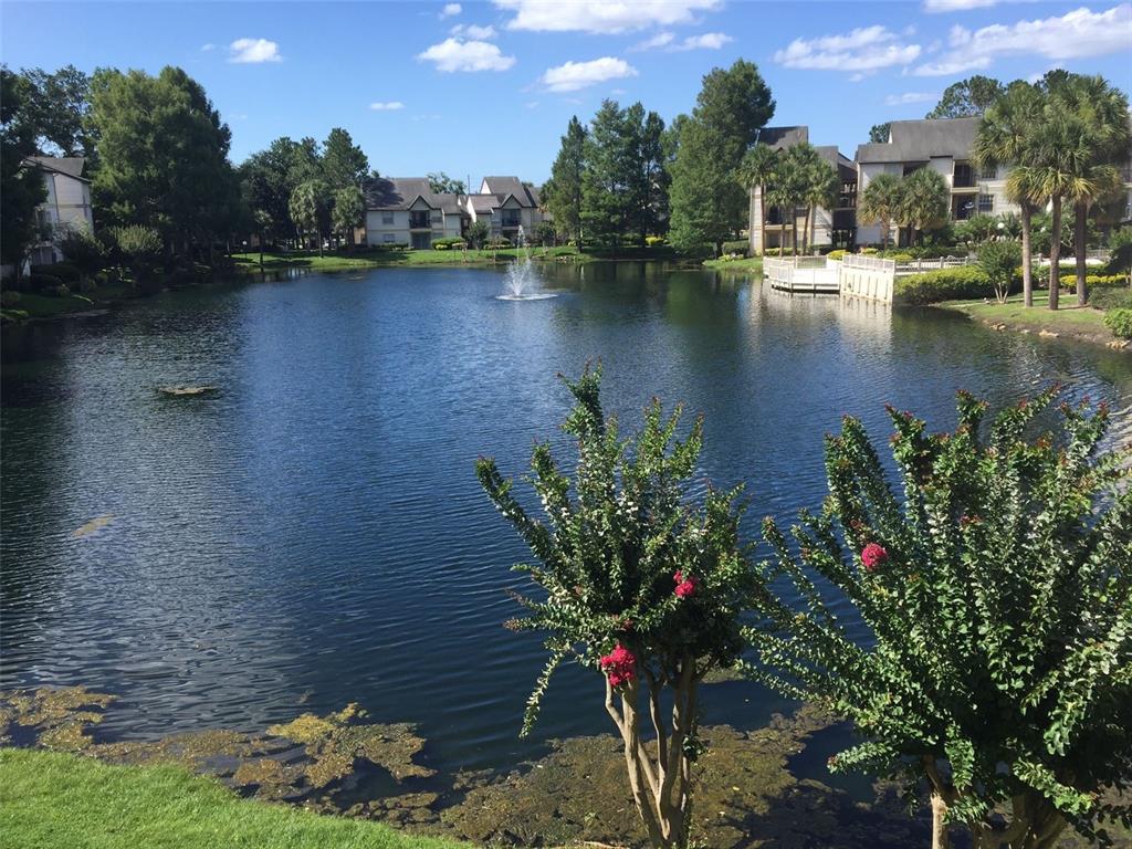 A pond with a fountain sits in front of apartment buildings and landscaped grounds — 1908 LAKE ATRIUMS CIRCLE UNIT 14, ORLANDO, FL
