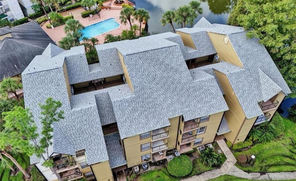 An aerial view of a multi-story apartment building with a gray shingled roof — 1908 LAKE ATRIUMS CIRCLE UNIT 14, ORLANDO, FL