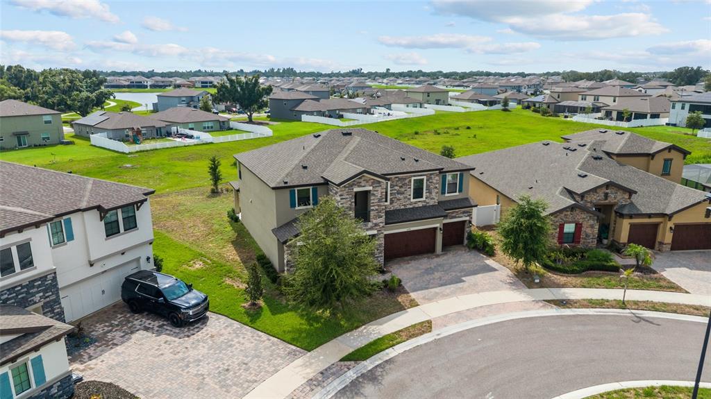 An aerial view shows suburban houses with stone facades, paved driveways, and surrounding green lawns — 12795 FISHERVILLE WAY, RIVERVIEW, FL