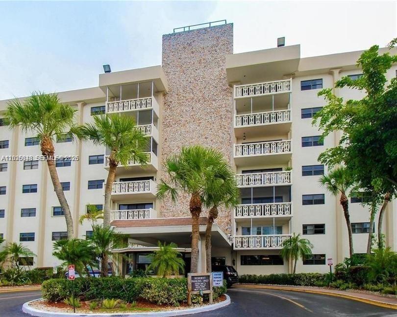 The exterior of a multi-story residential building features balconies and a central stone facade — 800 NE 195th St # 720, Miami FL 33179, MIAMI, FL
