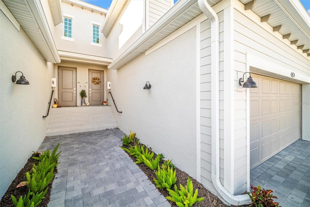 A paved walkway leads to a set of stairs and two front doors — 17740 BORACAY COURT UNIT 202, VENICE, FL