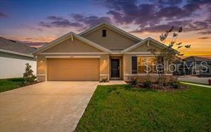 A single-story suburban house with a tan exterior, a two-car garage, and a concrete driveway — 4163 SW 53RD LANE ROAD, OCALA, FL