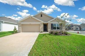 A single-story house with a beige exterior, a two-car garage, and a green lawn — 4163 SW 53RD LANE ROAD, OCALA, FL