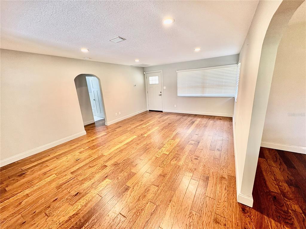 An empty living room features hardwood floors, recessed lighting, and an arched doorway — 438 LAKEVIEW AVENUE, WINTER PARK, FL