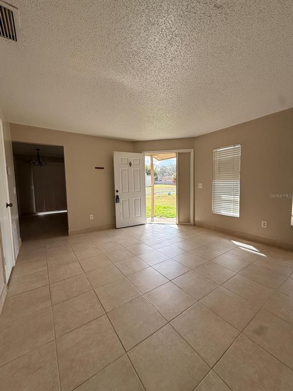 An interior view of a tiled living room with an open front door — 965 BRYAN COURT, LONGWOOD, FL