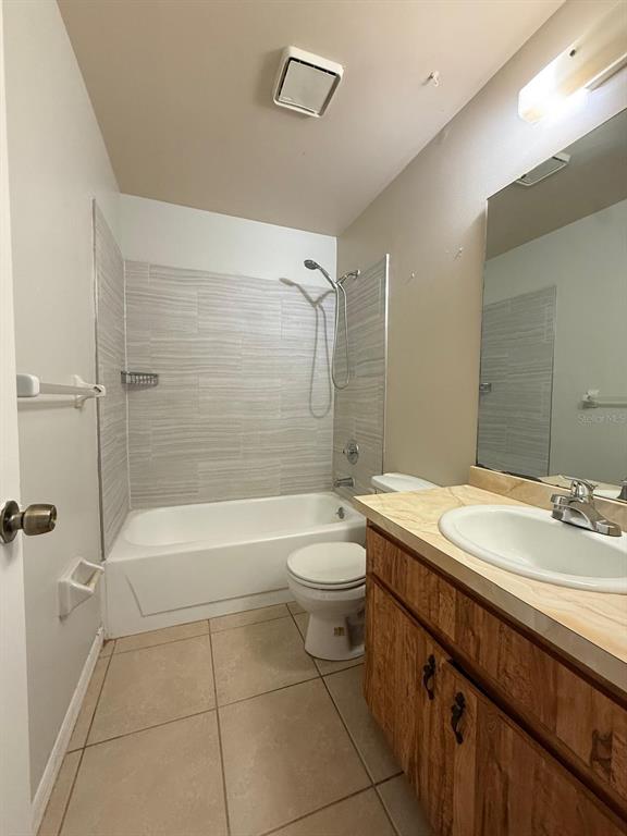 A bathroom with a tiled shower-tub combo, a toilet, and a wood-toned vanity with sink — 965 BRYAN COURT, LONGWOOD, FL