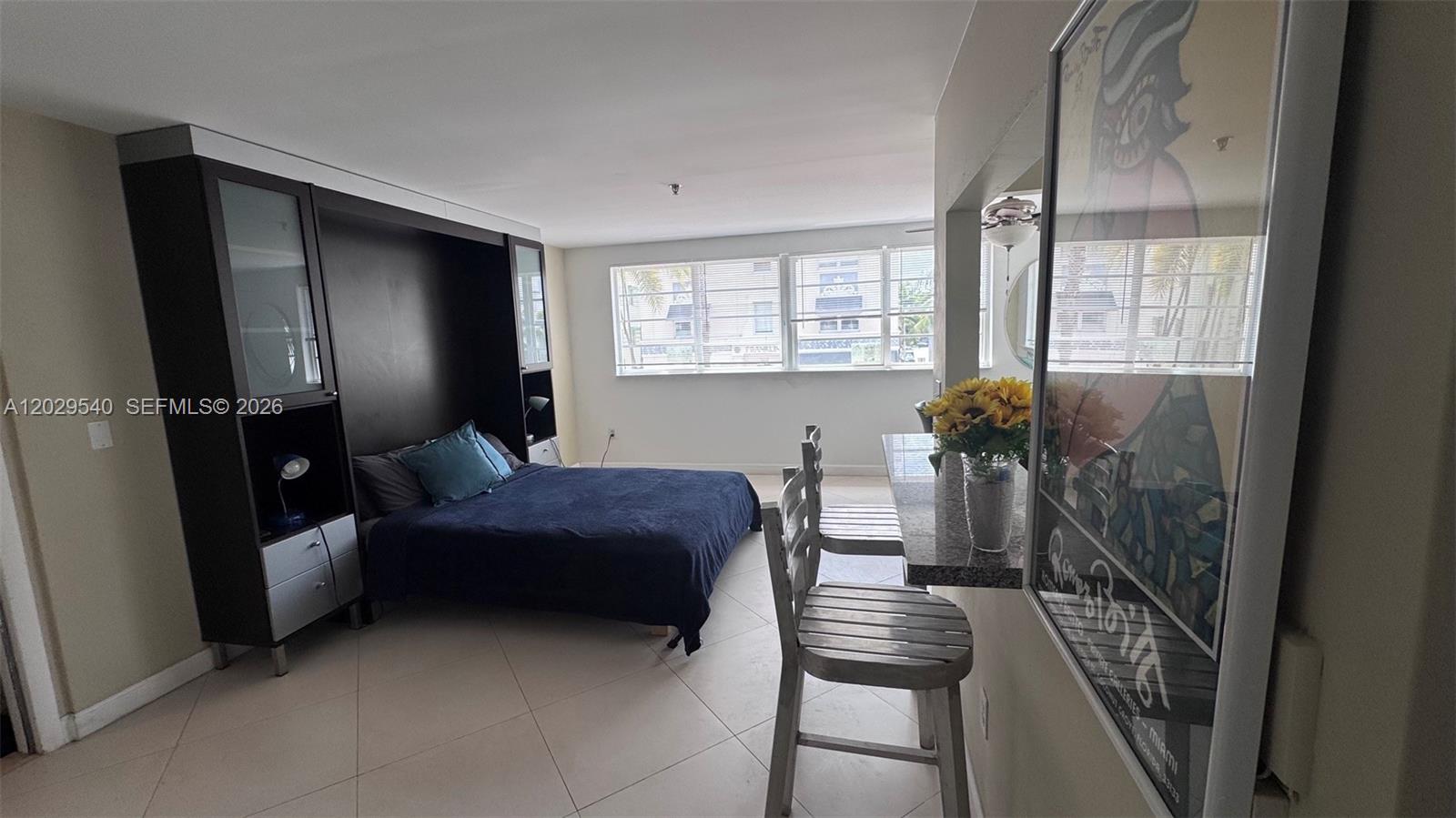 A studio apartment features a Murphy bed, tile flooring, and a breakfast bar with stools — 865 Collins Ave # 210, Miami Beach FL 33139, MIAMI BEACH, FL