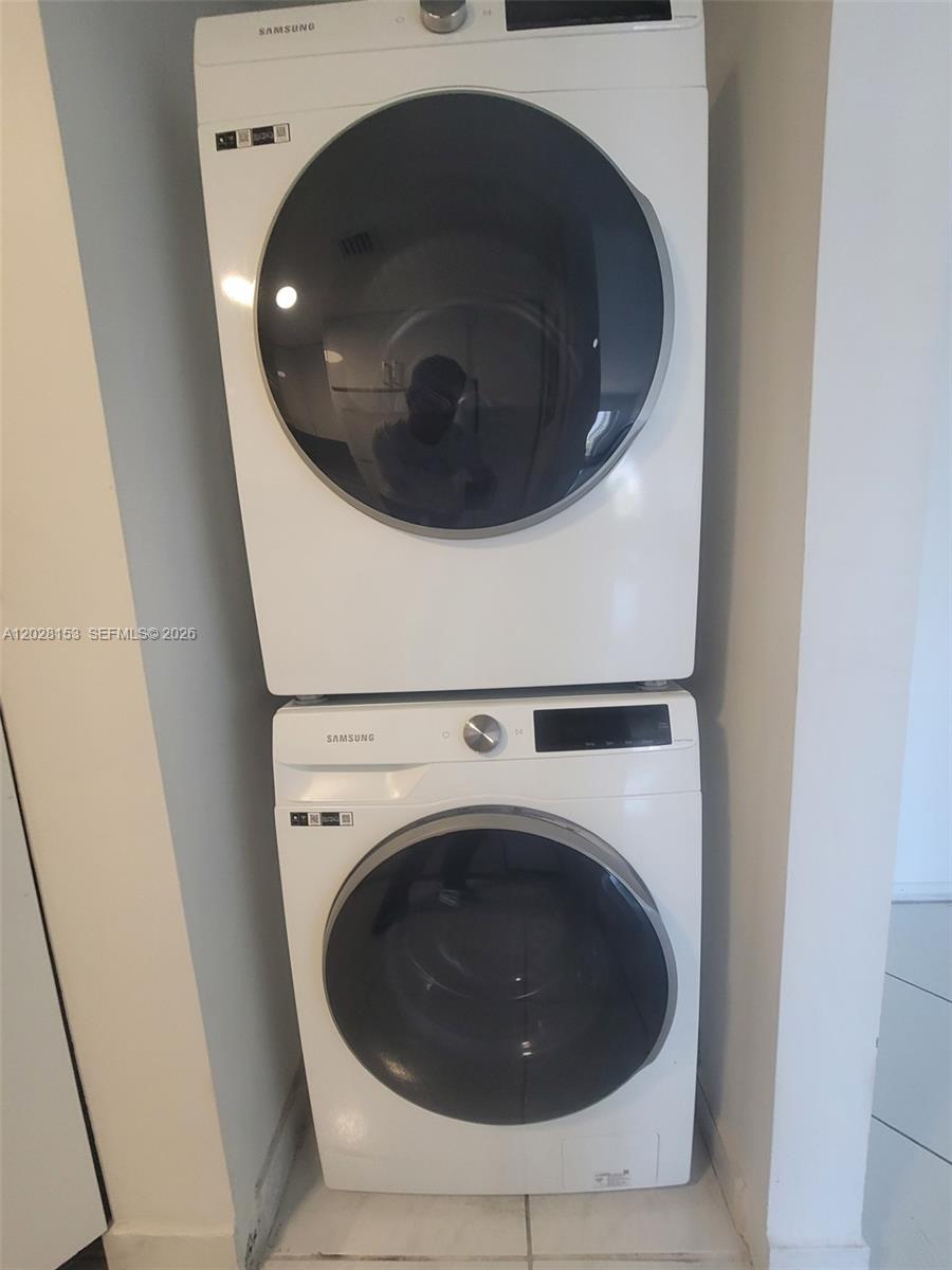 A white Samsung washer and dryer are stacked vertically in a small laundry closet — 2600 Collins Ave # 411, Miami Beach FL 33140, MIAMI BEACH, FL