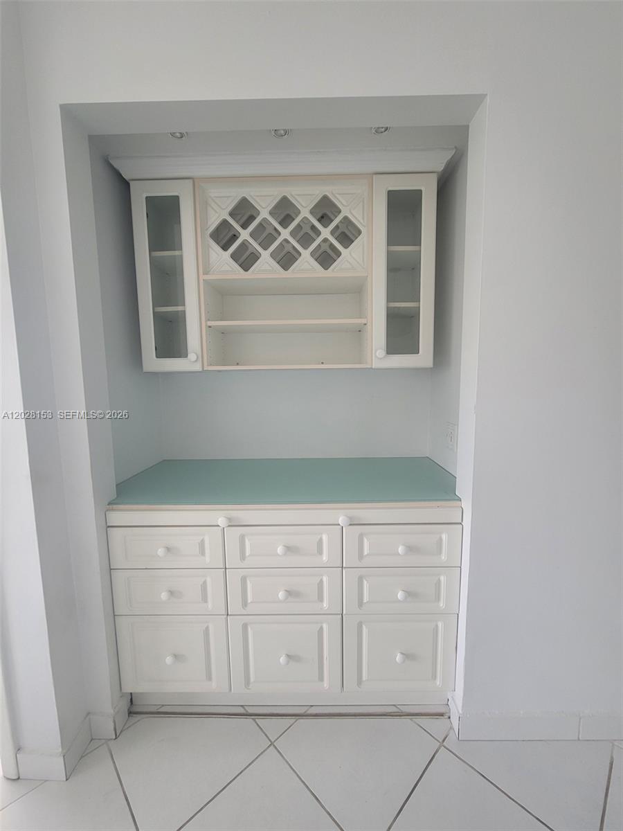 A built-in white cabinet unit with a wine rack and light blue countertop — 2600 Collins Ave # 411, Miami Beach FL 33140, MIAMI BEACH, FL