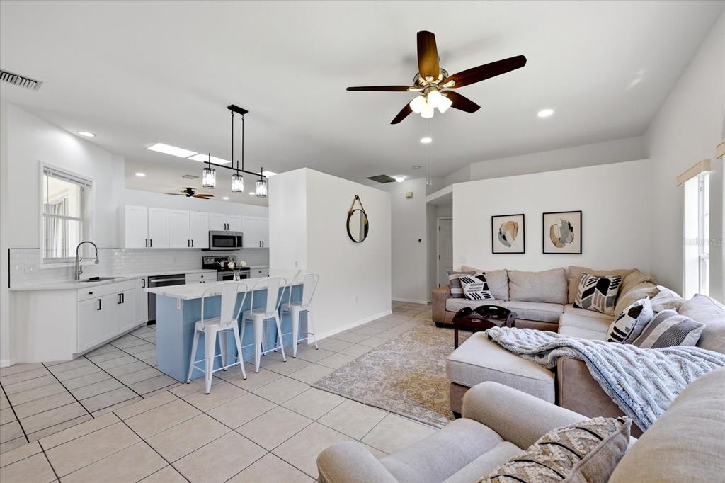 A bedroom features a bed, wood flooring, a ceiling fan, and sliding doors overlooking water — 6223 ROCK CREEK CIRCLE, ELLENTON, FL