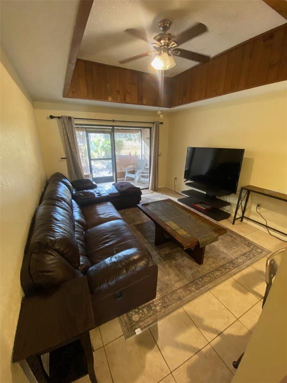 A living room features a brown leather sofa, a coffee table, and a ceiling fan — 6120 TOPHER TRAIL UNIT 6120, MULBERRY, FL