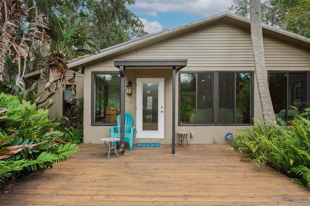 A wooden deck leads to the front entrance of a house with beige siding — 4521 EDITH STREET, NEW PORT RICHEY, FL
