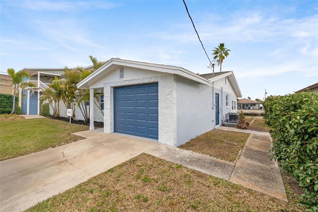 A light-colored house with a blue garage door and a concrete driveway — 13804 VICTOR AVENUE, HUDSON, FL