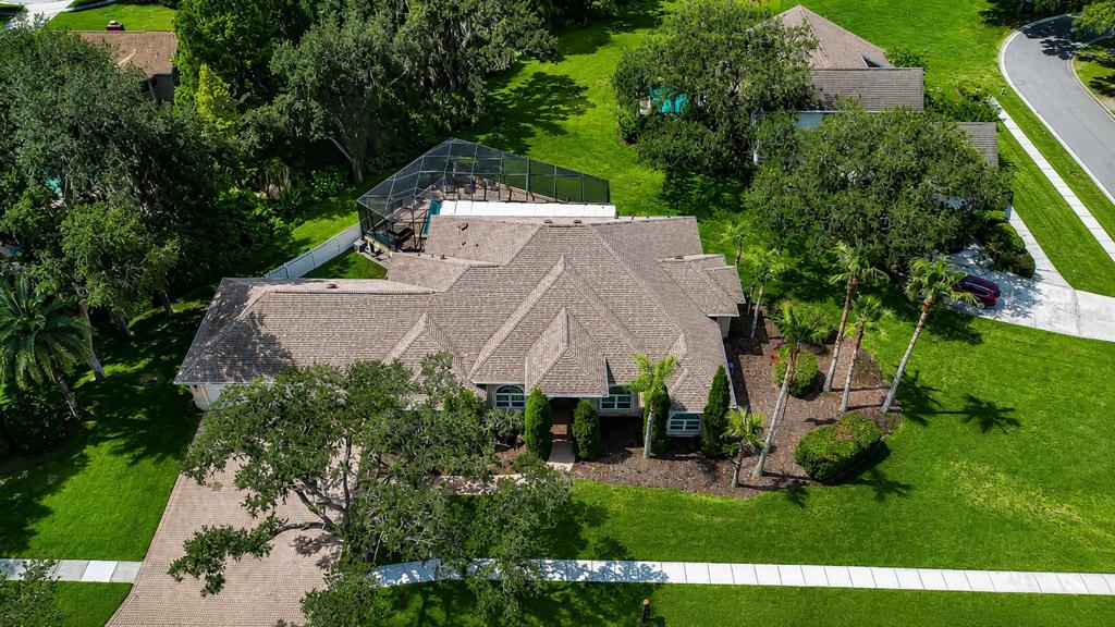 An aerial view of a suburban house with a screened-in pool and a paved driveway — 1009 EMERALD CREEK DRIVE, VALRICO, FL