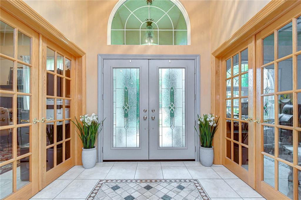 An entryway features a double front door with glass inserts, flanked by two sets of French doors — 1009 EMERALD CREEK DRIVE, VALRICO, FL