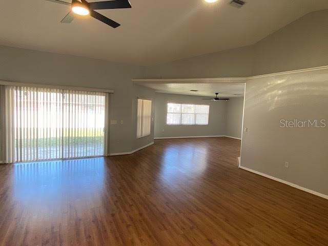An open-concept living area features light gray walls, wood-look flooring, and a ceiling fan — 8427 SW 136TH STREET, OCALA, FL