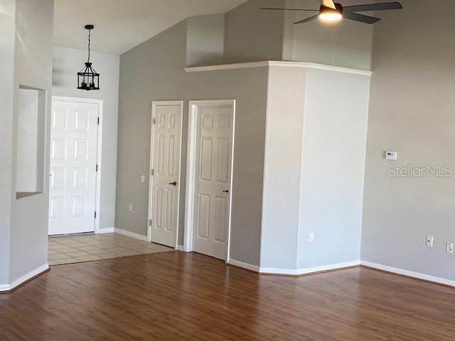An interior view shows a room with light gray walls, wood flooring, and two doors — 8427 SW 136TH STREET, OCALA, FL