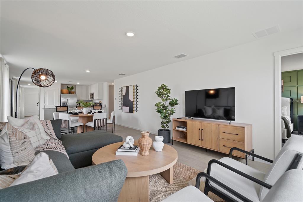 A living room with a gray sectional, round coffee table, and television on a wooden console — 3448 ROVER ROAD, EAGLE LAKE, FL