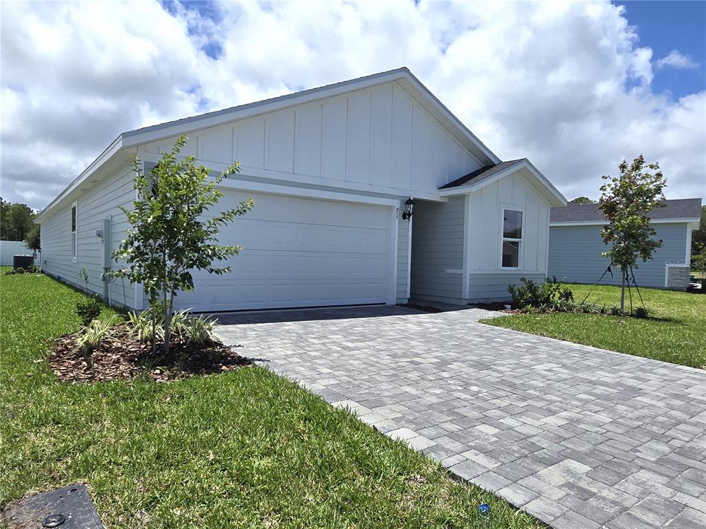 A single-story house with a white garage, light siding, and a paved driveway — 71 ARARAT DRIVE, PALM COAST, FL