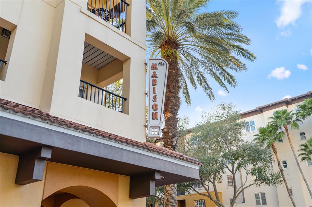 A vertical sign for The Madison stands next to a palm tree and apartment building — 100 4TH AVENUE S UNIT 115, ST PETERSBURG, FL