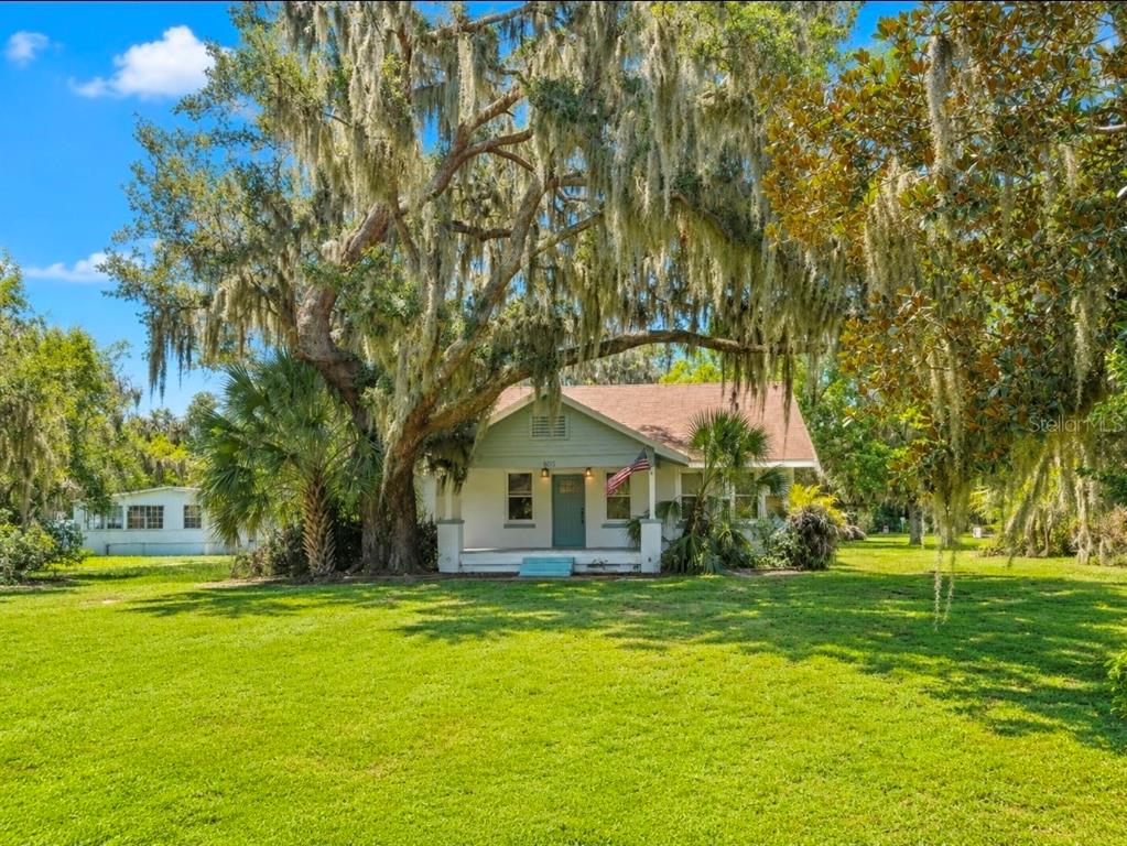 A single-story house with a front porch sits under a large tree with Spanish moss — 695 LYLE PARKWAY, BARTOW, FL