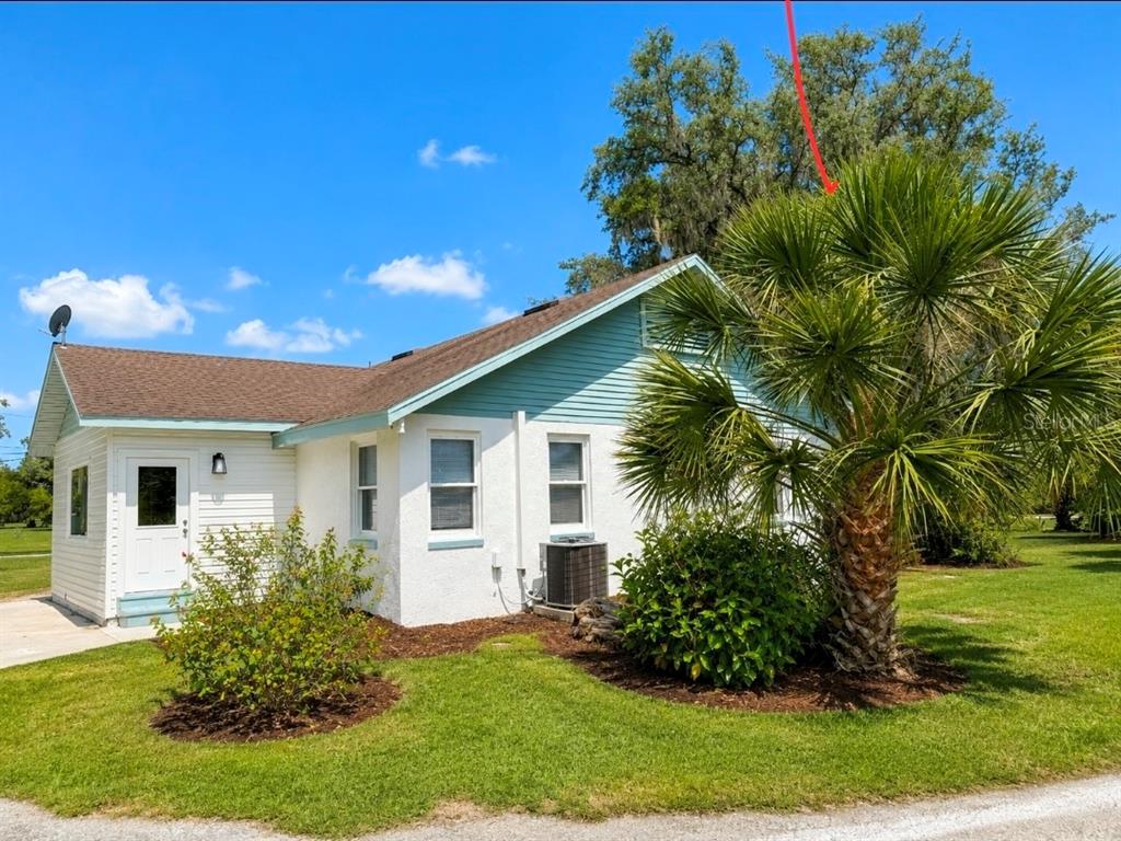 A white house with light blue siding and a palm tree in the front yard — 695 LYLE PARKWAY, BARTOW, FL
